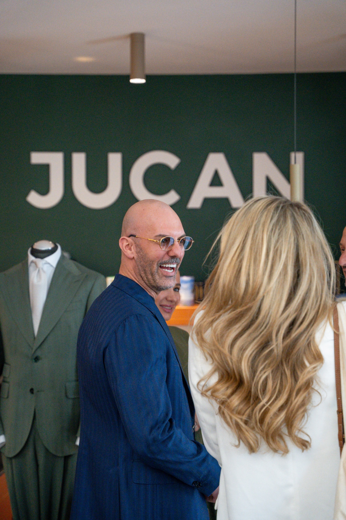 JUCAN Store — Gast vor grüner JUCAN-Wand